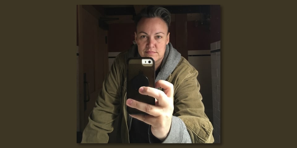 Leoh wearing a green corduroy hoodie, taking a selfie in a bathroom at Cape Disappointment.