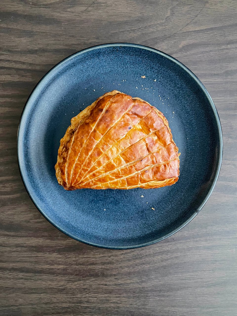 A large pastry that looks like a ham on a blue plate