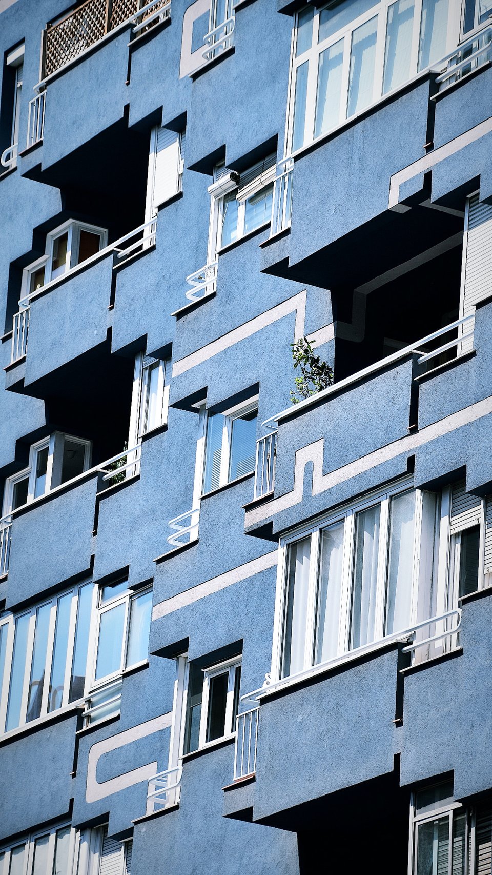 A blue art deco façade of an apartment building.