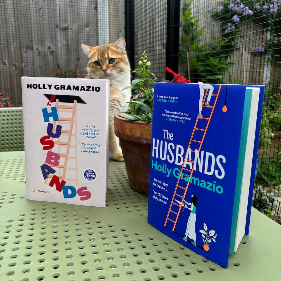 US and UK copies of The Husbands, with a cat behind them