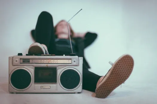 a woman laying on the floor next to a boombox