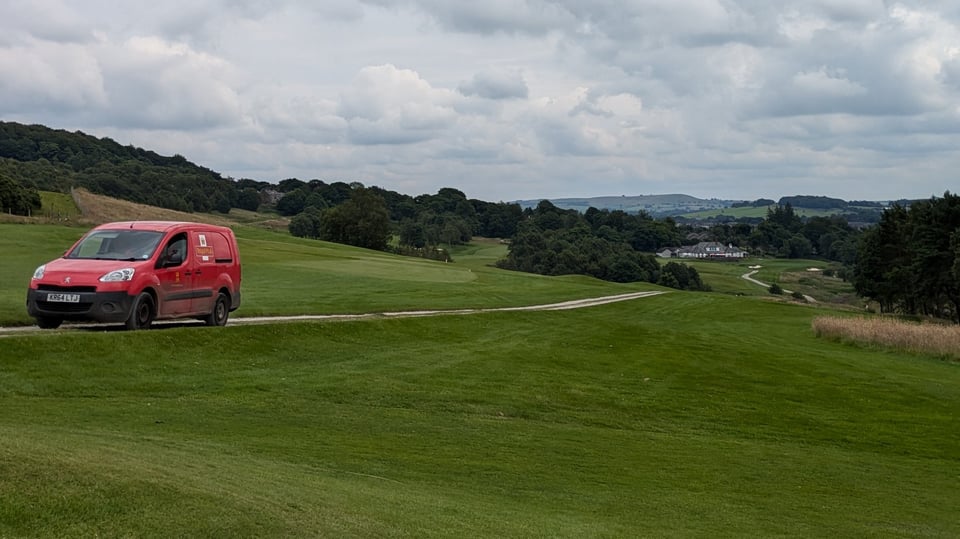 Postal worker driving up the sloping 16th fairway at Cavendish, Buxton
