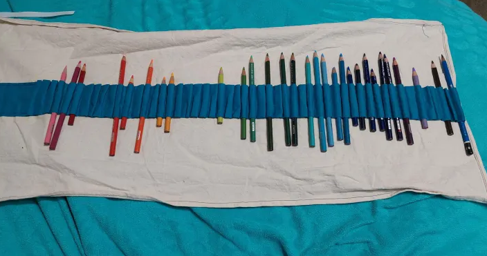 On open fabric roll of pencils, each with their own slot.