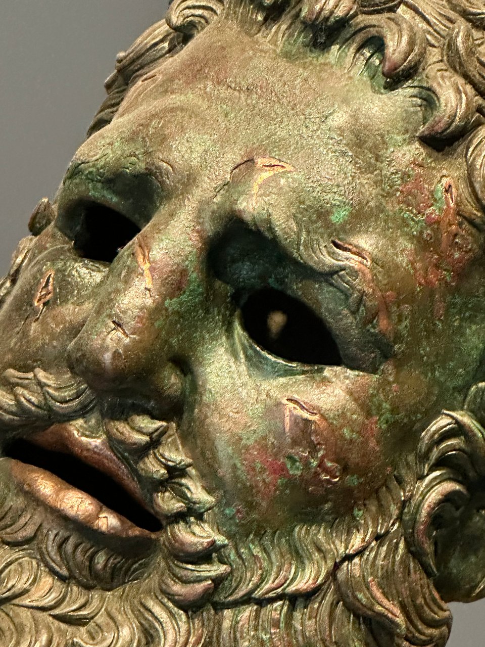 Close-up photo of the face of the Boxer At Rest statue, with a little light visible inside its head