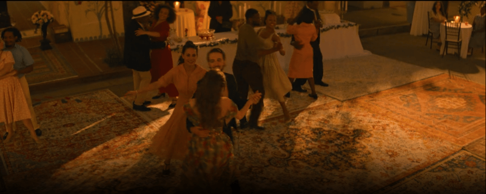 Brynn, her previously dismissive neighbor, and another person from town dance together at the center of a town-wide party. Others we've seen through the rest of the movie are also dancing together. Everyone is dressed as if they're from the 50s and it's shot in Golden Hour sepia tones.