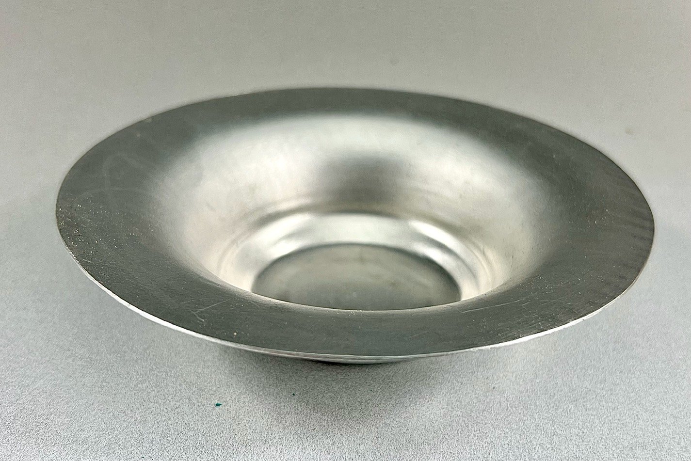 An aluminum bowl with a flat bottom and a wide rim