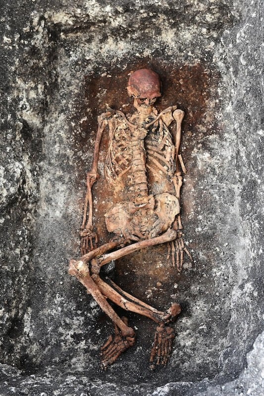 A skeleton of a Bronze Age man in a burial pit.