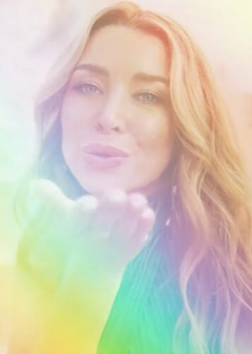 A person blowing a kiss; the image is filtered through a rainbow
