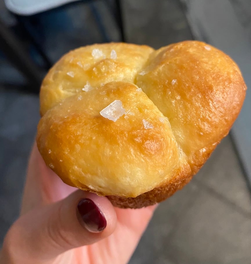 A baked 3-cloverleaf roll with flaky salt on top.