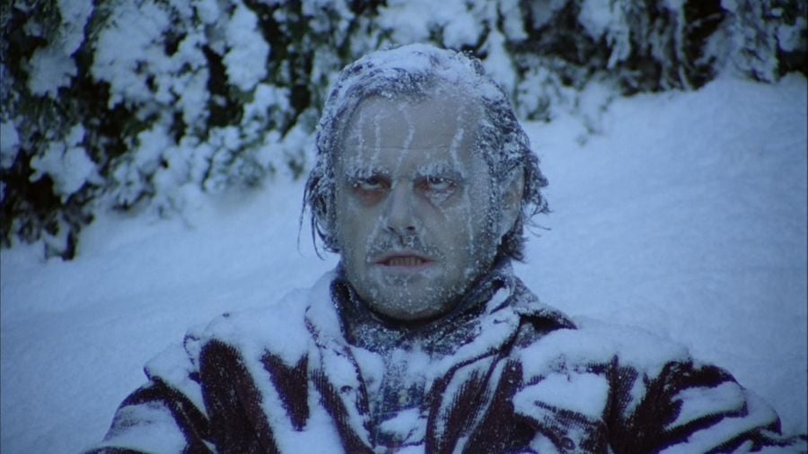 Jack sits in the snow, frozen to death, his eyes rolled back in his head, ice and snow covering his face, hair, and clothing.