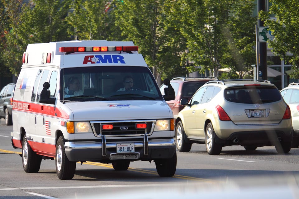An AMR ambulance drives through the streets of Seattle on a sunny day