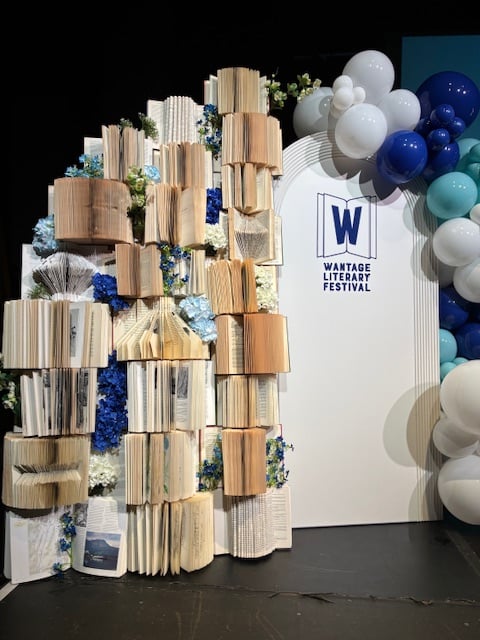 A large display with books, balloons, garlands, and a sign saying Wantage Literary Festival.