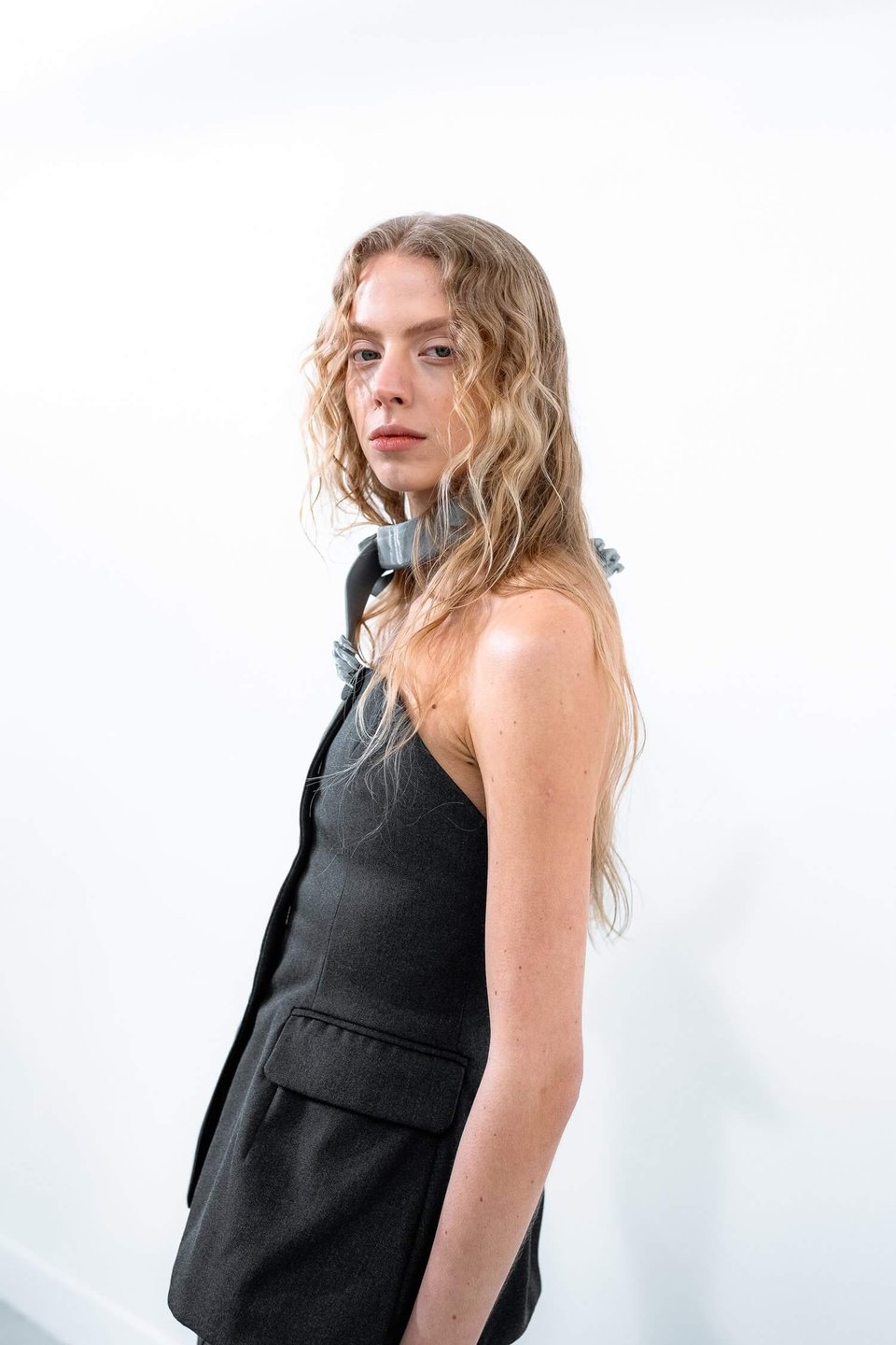 A person wearing a gray neckpiece that morphs into paws