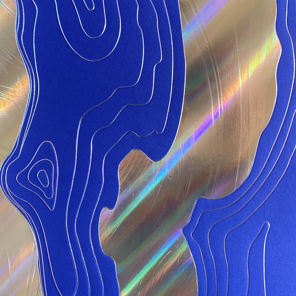 a surface mixed of blue and silver-holographic glowing paper