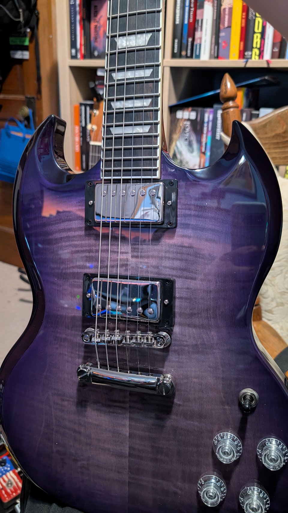 An Epiphone SG Modern guitar with shiny and somewhat reflective "purple burst" finish.