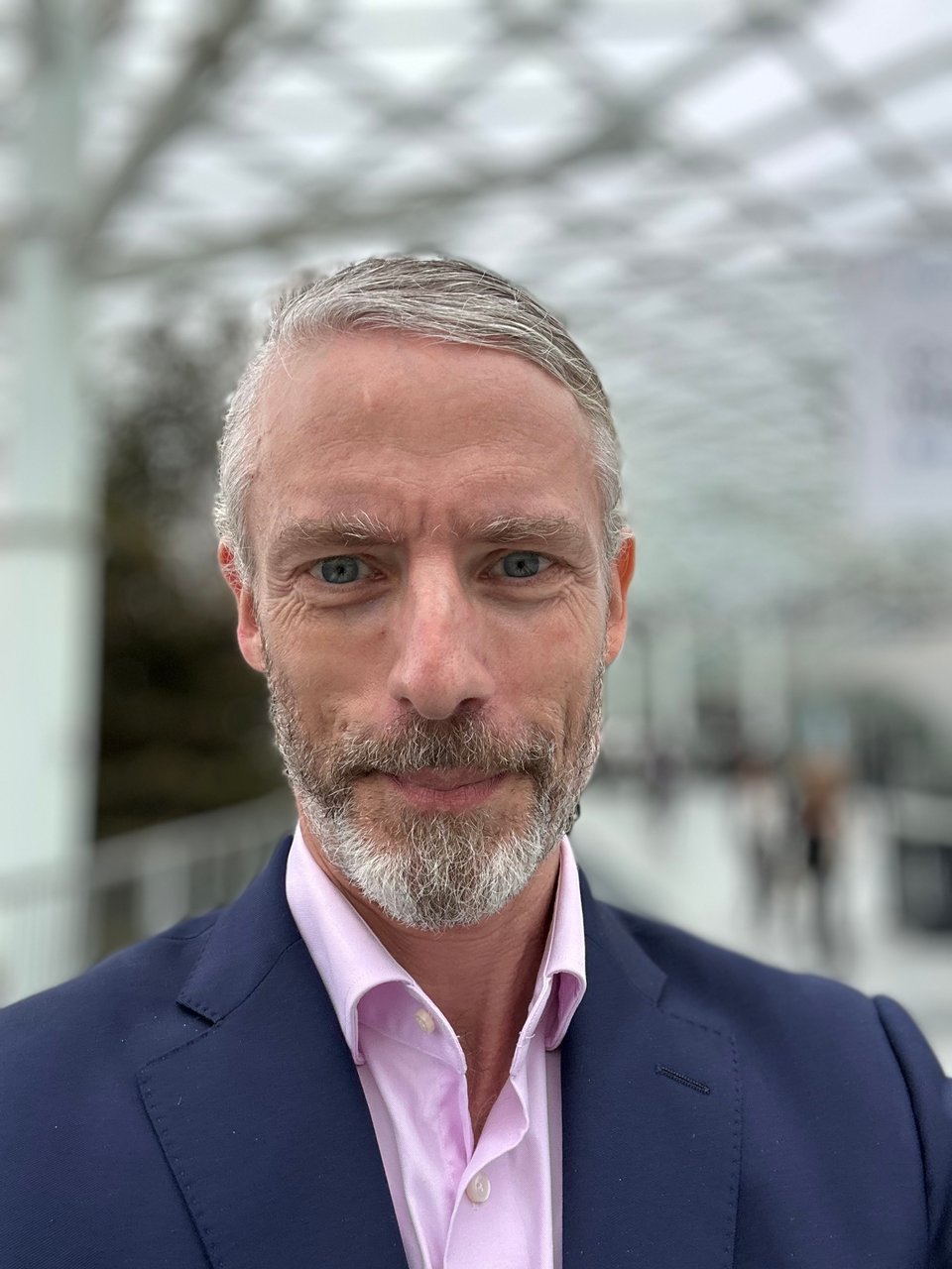 portrait-selfie of white man in navy suit w/pink dress shirt