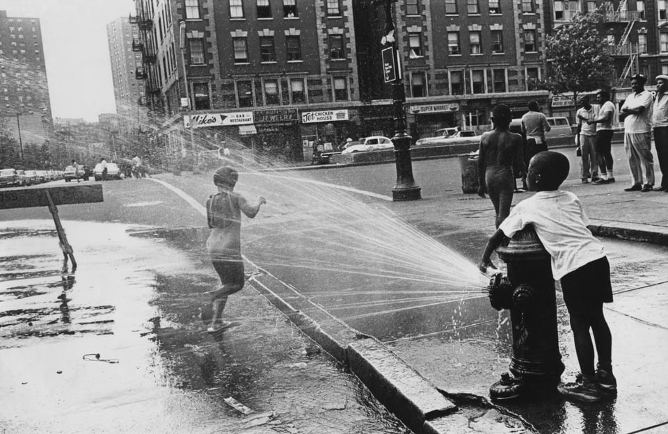 two children playing with a fire hydrant