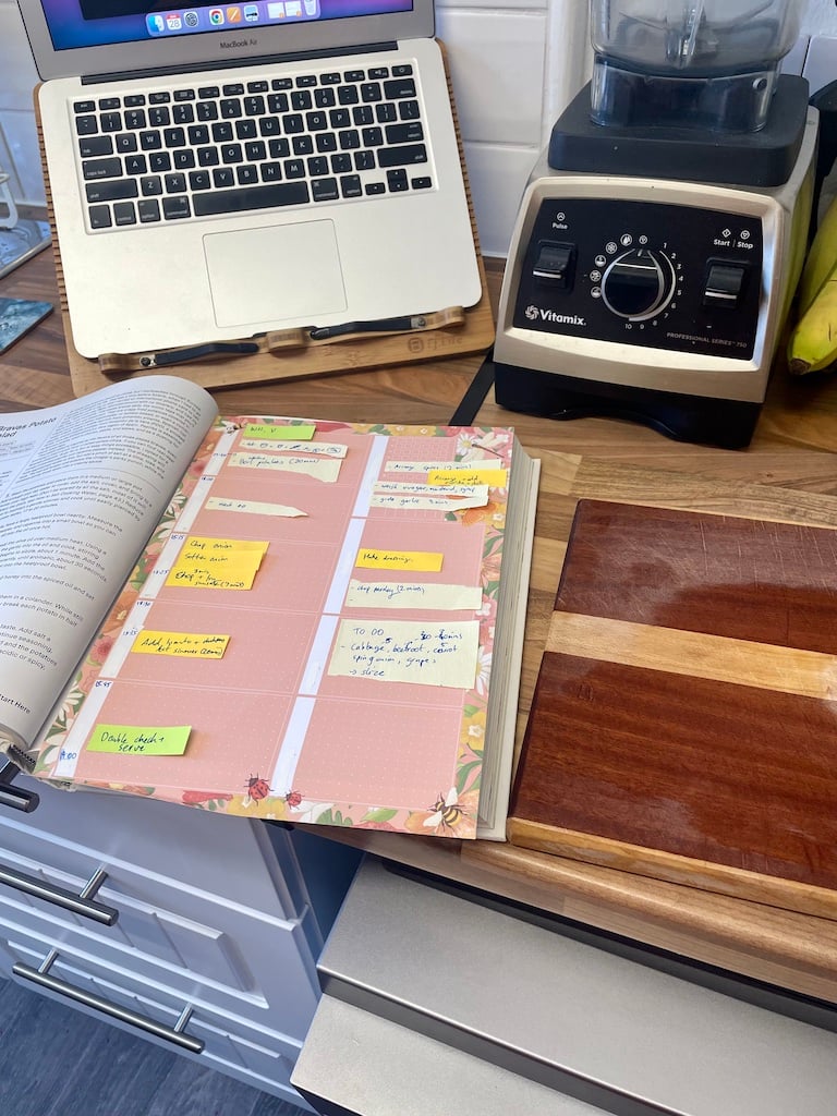 Notes organised on a pink page in a kitchen setting
