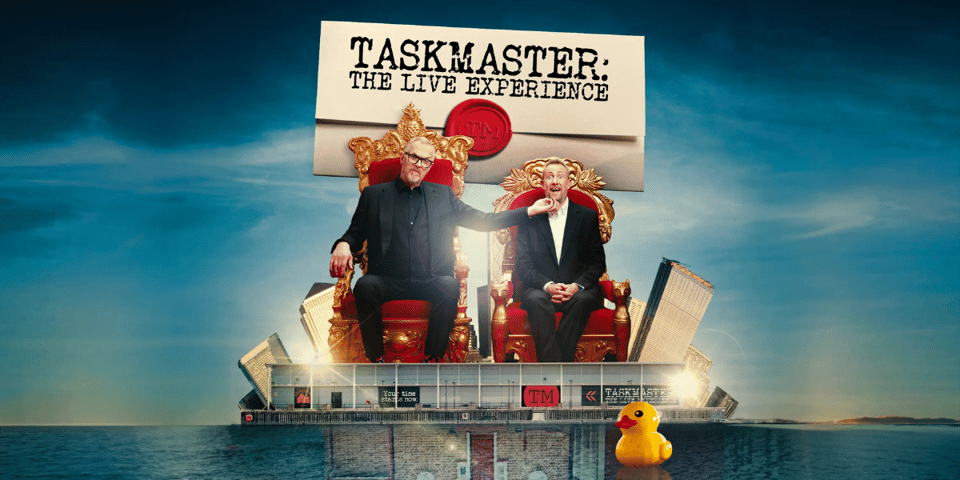 Greg and Alex from Taskmaster sitting on thrones atop the Taskmaster Live building.