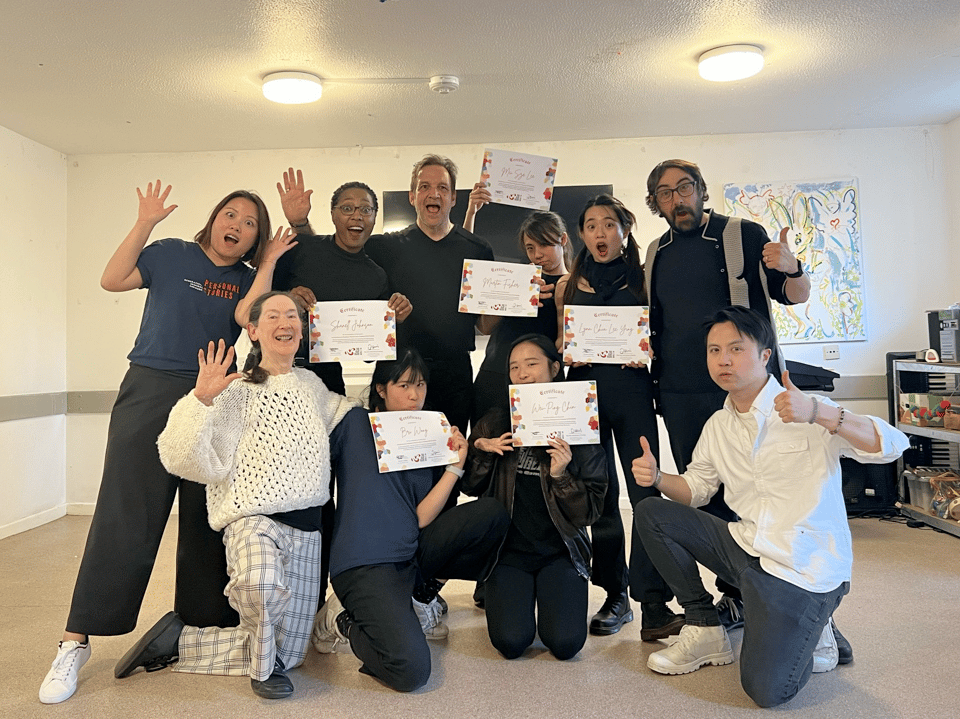 People waving at the camera holding a diploma after compliting a course