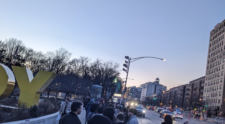 a line of people on Eastern Parkway in Brooklyn, NY near the Central Library.
