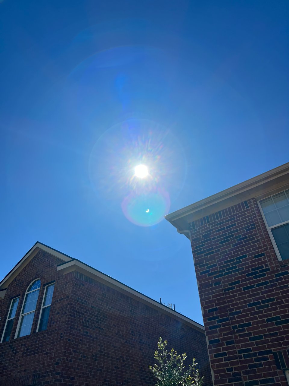 October 2023 annular eclipse as seen from McKinney, TX. The sun is washed out, but you can clearly see the event in a lens flare.