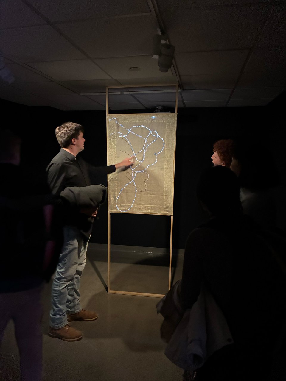 Paul viewing Karlie’s installation and tracing a line of projected poetry with his finger.