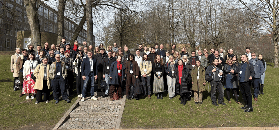Large collection of most white people in coats posing for the camera in the sunshine.