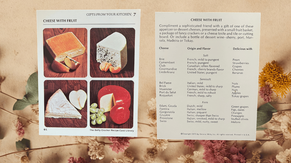 Cheese with Fruit recipe card. Four different kinds of cheese with fruit including, apples, pears, grapes, and mandarin oranges. The cheeses are swiss, brie, blue cheese, and random fourth one that I don’t recognize
