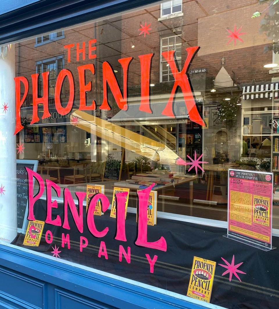 Window display mimicking The Phoenix Pencil Company cover, with a huge pencil dangling in the middle