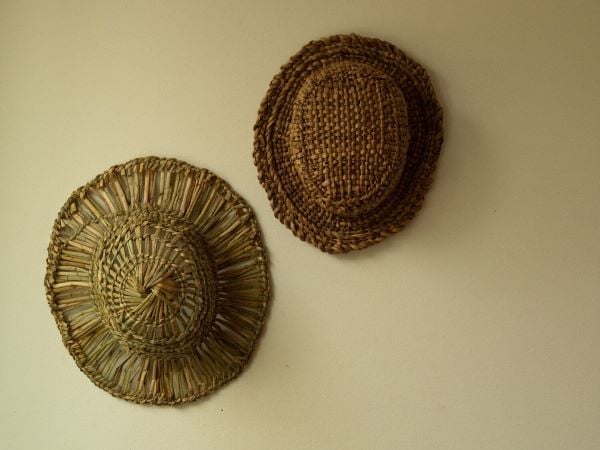 Bulrush woven hats hung on a wall