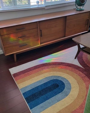 A medium-brown console with two doors and three drawers. It sits under a large window