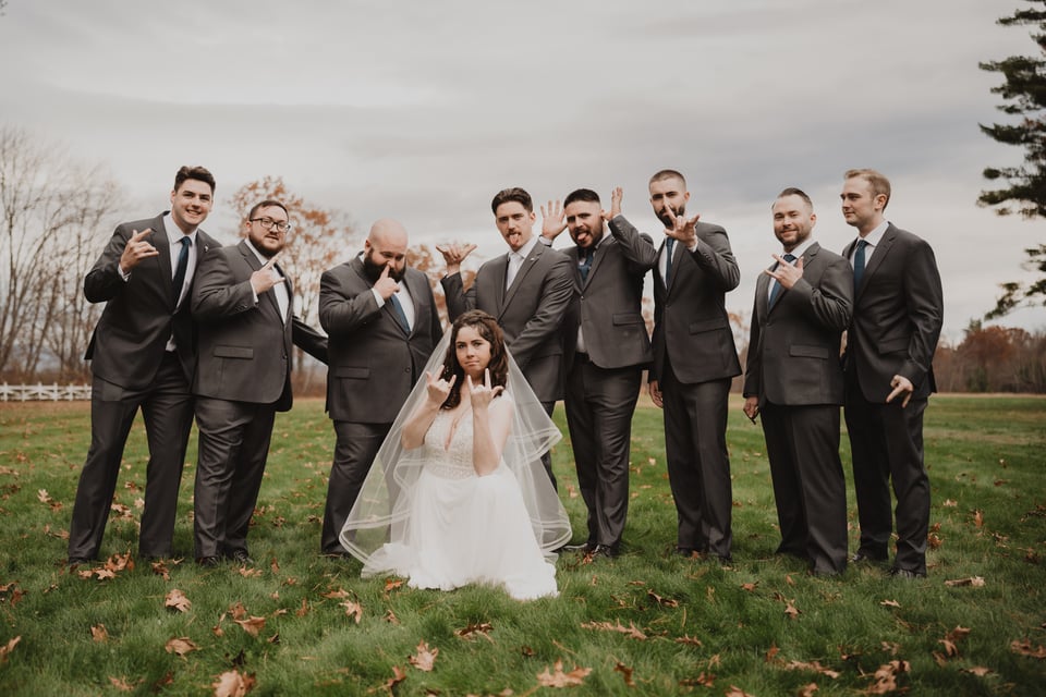bridesmaids and groomsmen posing for a photo, making satanic hand gestures, lol