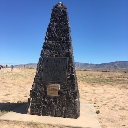 An obelisk made from rugged basaltic lava rock at ground zero for the Trinity Site. A plaque reads: "Trinity Site where the world's first nuclear device was exploded on July 16, 1945"