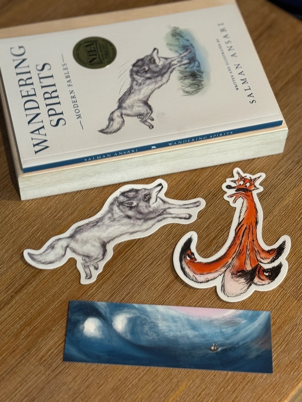 Wandering Spirits paperback edition with wolf and fox stickers, and bookmark