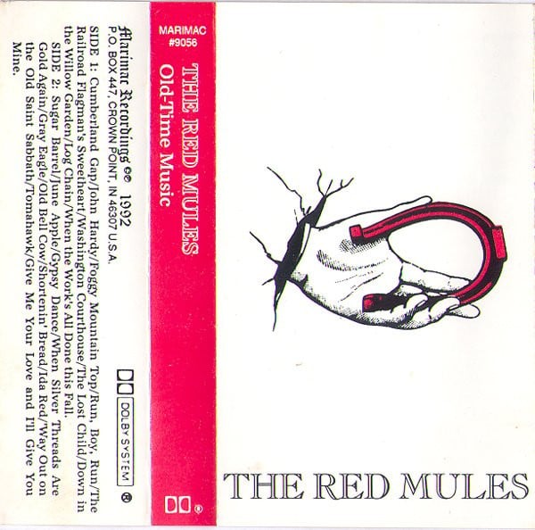 Scan of a tape sleeve for "Old-Time Music" by the Red Mules. The cover just has the words THE RED MULES at the bottom, along with an illustration of a persons hand holding a red horseshoe