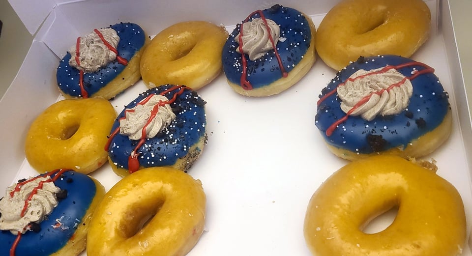 Box of donuts. Half are iced to look like the Artemis logo. Half are regular glazed. I think they're from Krispy Kreme.