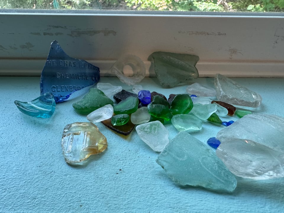 A large pile of river glass on a windowsill.