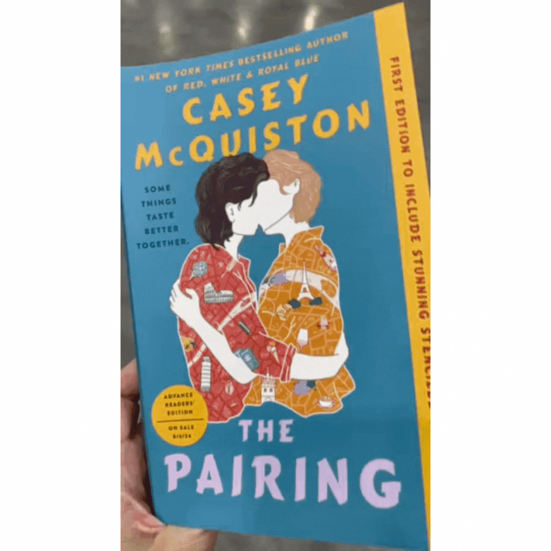 K's hand opens the cover of an ARC of The Pairing, which is signed on the title page by author Casey McQuiston: "For the Book Bike!"