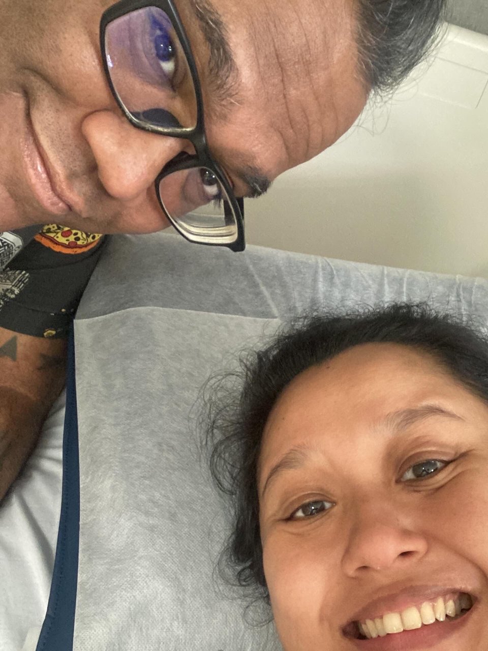 Nadia lying in her hospital bed, with me leaning in next to her.