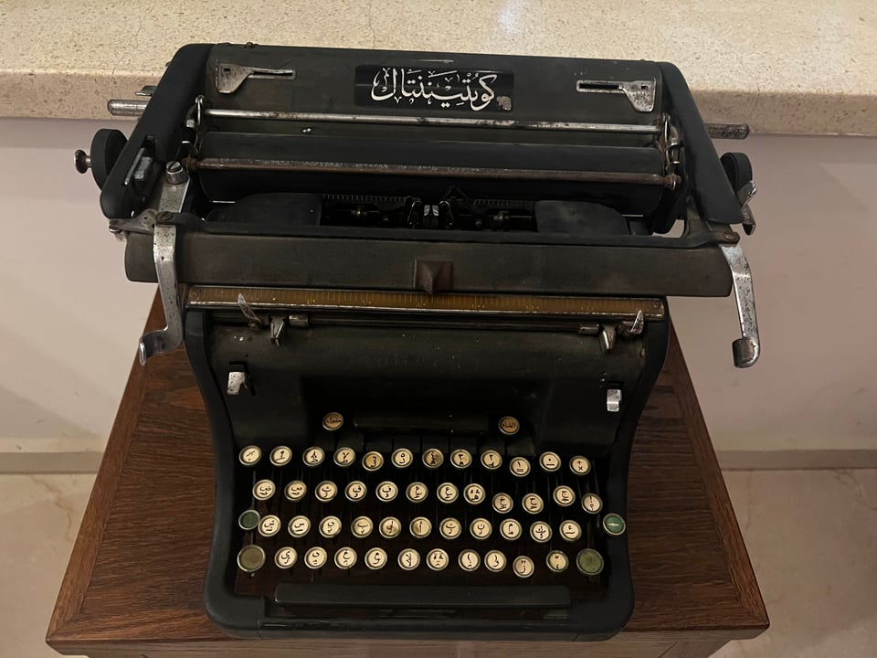 An old manual typewriter, wtih Arabic writing and each key imprinted with an Arabic letter