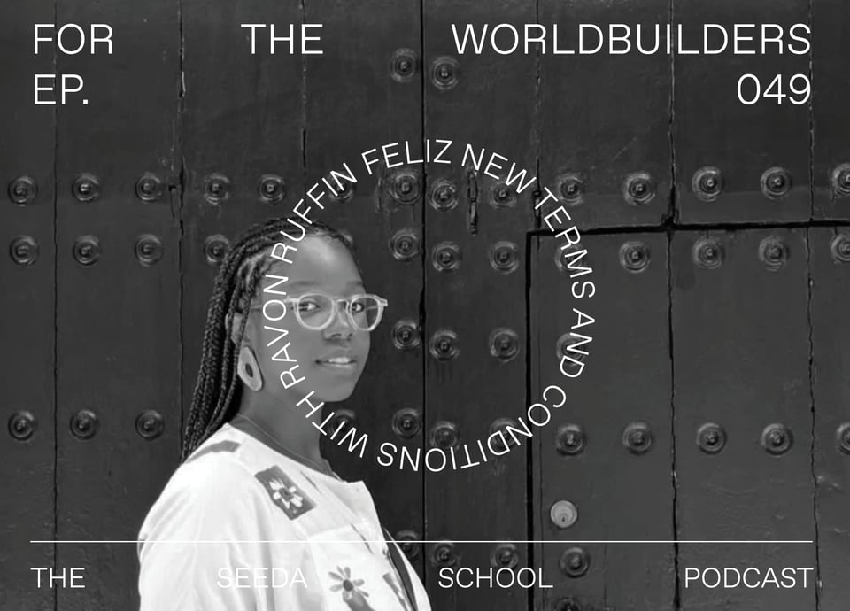 Black and white photo of me standing in front of a black door wearing Fulani braids, a white jumpsuit featuring flowers and a pair of clear eyeglass frames while staring directly into the camera with a soft gaze and even softer smile. This photo was taken by my wife on our honeymoon last year while in Spain.
