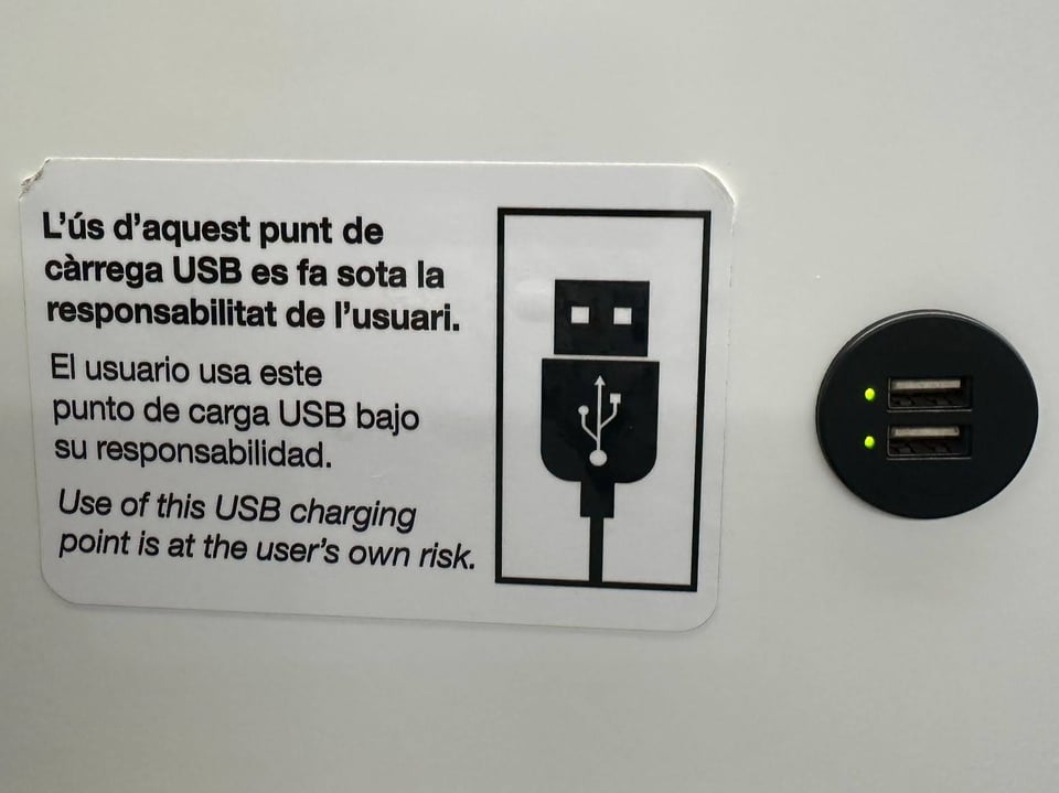 A sticker next to two USB ports that says "Use of this USB charging point is at the user's own risk. It also has the same message in French and Spanish.