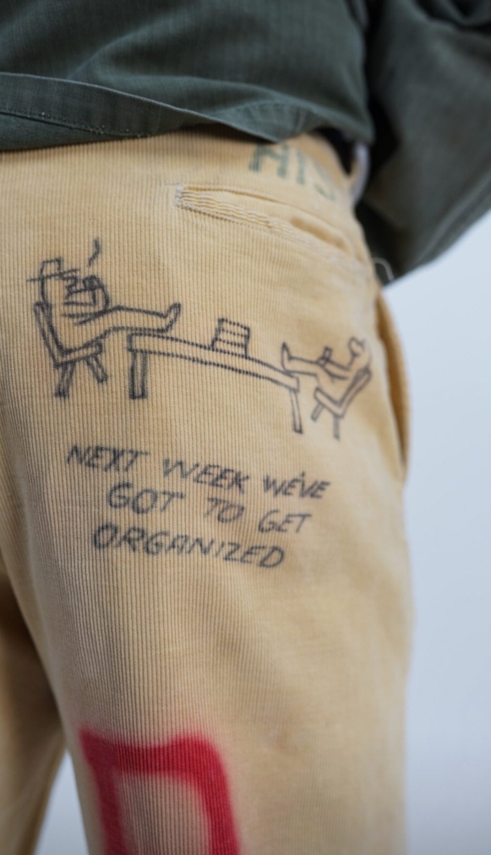 drawing of two people their feet up; "Next week we've got to get organized" on a pair of khakis