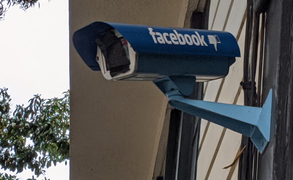 big old fashioned security camera with facebook logo and a thumbs down, and the lens is covered with duct tape