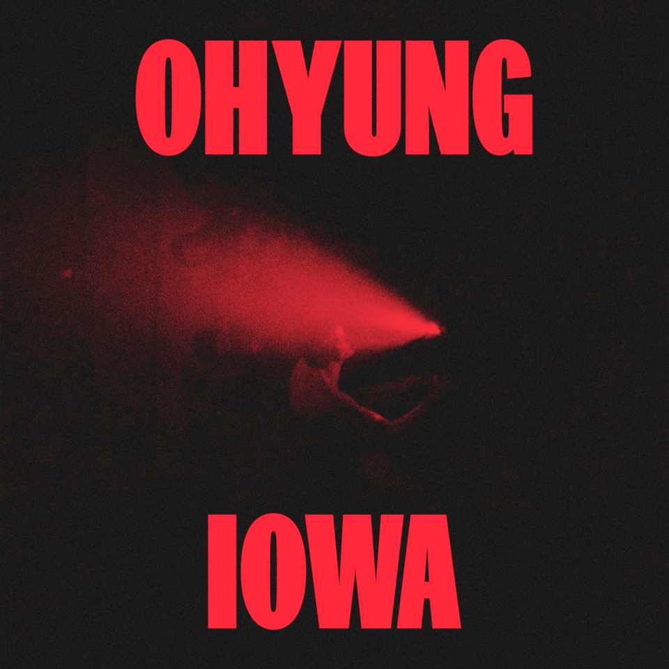 Album Cover: Large bold red text saying OHYUNG IOWA, with a hazy photo of OHYUNG in a black void with a red light pointed on her face