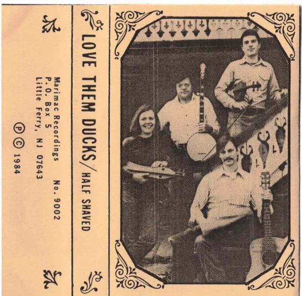 Tape sleeve for Love Them Ducks by Half Shaved; there is a black and white photograph of four people standing on and by a staircase holding instruments