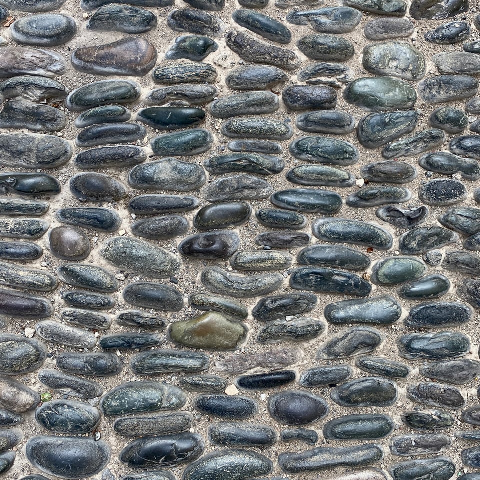 Photo of a wall with vertically piled up cobble stones