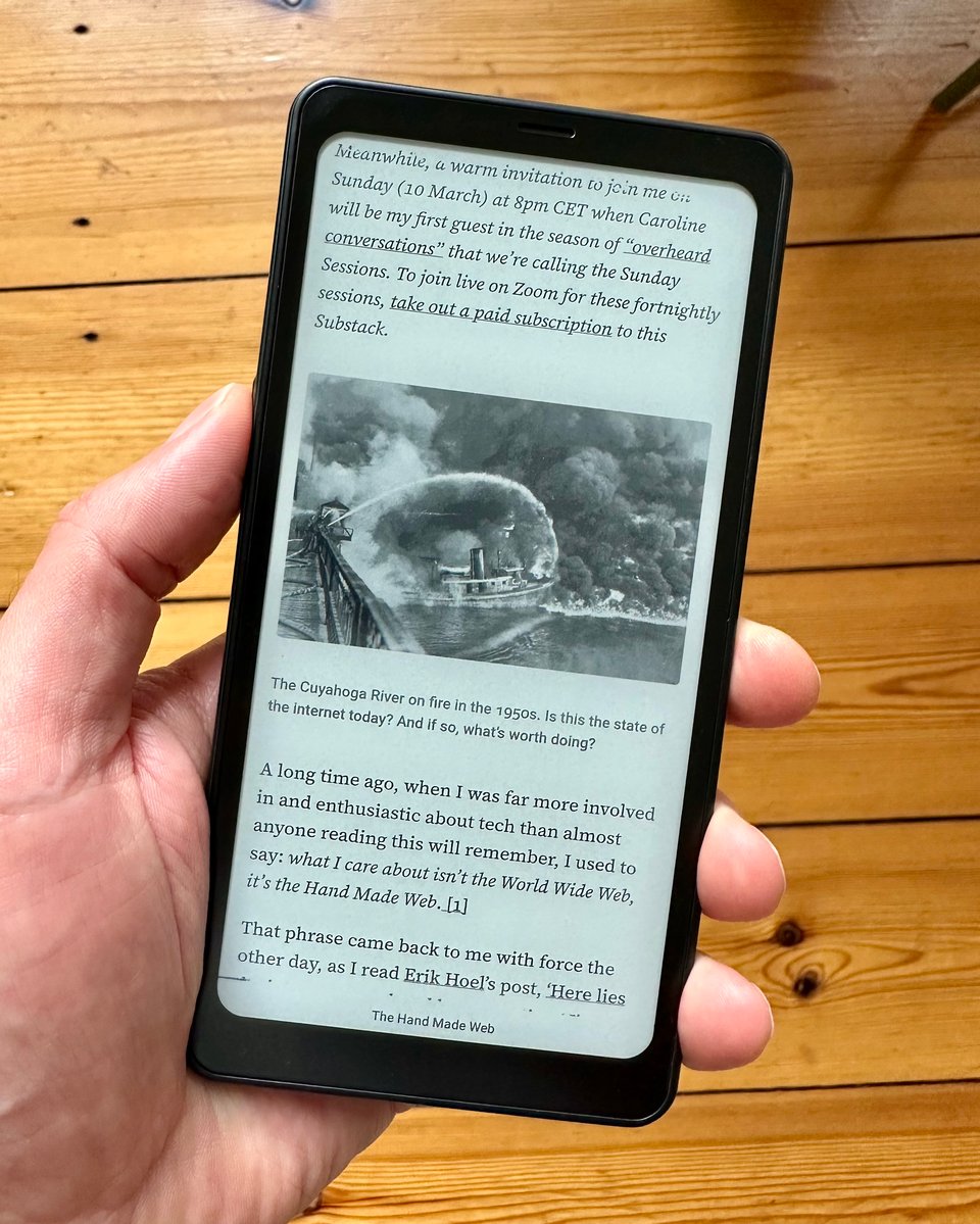 a person holding an eInk phone with a book on it