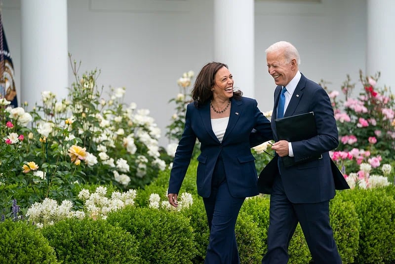 Image of Pres Biden and VP Harris walking outside the White House